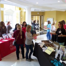 A volunteer and guest interact at the4 Angel Cakes/ body image table