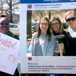 WGRC student assistants and an intern pose with an instagram photo frame and poster