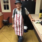 A man poses in a kitchen wearing an Alabama apron