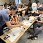 Participants at the 2024 Chinese Calligraphy Workshop attempt their own calligraphy following a lesson