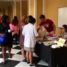 Guests visit a table featuring chocolate goodies and information on healthy relationships