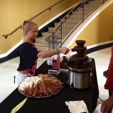 Guest dips marshmallow in chocolate fountain